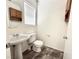 Compact bathroom features a pedestal sink, tile flooring, and a framed mirror at 10381 Poker Alice Ct, Las Vegas, NV 89129