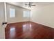 This bedroom features multiple windows and beautiful laminate wood floors at 10381 Poker Alice Ct, Las Vegas, NV 89129