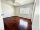 This bedroom features hardwood floors, a ceiling fan, and a bright window at 10381 Poker Alice Ct, Las Vegas, NV 89129