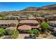 An aerial view of a home featuring a tile roof and mature landscaping in a neighborhood with mountain views at 10433 Ember Rose Ave, Las Vegas, NV 89135