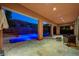 Outdoor patio with a sparkling pool, spa, lush landscaping, and ambient lighting perfect for evening enjoyment at 10433 Ember Rose Ave, Las Vegas, NV 89135