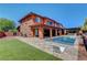 Gorgeous backyard with a pool, outdoor kitchen, and ample seating, perfect for gatherings and leisure at 10433 Ember Rose Ave, Las Vegas, NV 89135
