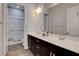 Bathroom featuring double sinks, framed mirrors, walk-in shower with white tile, and modern fixtures at 10433 Ember Rose Ave, Las Vegas, NV 89135