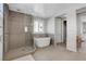 Bright bathroom features a glass enclosed shower and soaking tub under a window at 10433 Ember Rose Ave, Las Vegas, NV 89135