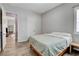 Clean bedroom design with wood look tile floors, a comfortable bed, and neutral color palette at 10433 Ember Rose Ave, Las Vegas, NV 89135