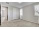 This bedroom features neutral tones, plush carpeting, a closet, and a window with a draped curtain at 10433 Ember Rose Ave, Las Vegas, NV 89135