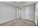 This bedroom features neutral tones, plush carpeting, an open doorway, and a window with a draped curtain at 10433 Ember Rose Ave, Las Vegas, NV 89135