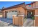 Inviting home entrance showcasing a three-car garage, gated walkway, and tidy landscaping at 10433 Ember Rose Ave, Las Vegas, NV 89135