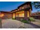 Exterior home view featuring brick accents, covered porch, paver driveway, and manicured landscaping at 10433 Ember Rose Ave, Las Vegas, NV 89135