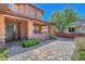 Charming home featuring a covered porch with brick accents and a beautifully paved driveway at 10433 Ember Rose Ave, Las Vegas, NV 89135
