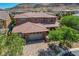 A well-maintained home exterior with a three-car garage, paved driveway, and mature landscaping at 10433 Ember Rose Ave, Las Vegas, NV 89135