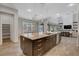 Gourmet kitchen with a large island, modern lighting, and an open layout to the living area at 10433 Ember Rose Ave, Las Vegas, NV 89135