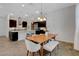 Open-concept kitchen and dining area with modern appliances, pendant lights, and a breakfast bar at 10433 Ember Rose Ave, Las Vegas, NV 89135