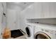 Functional laundry room with modern appliances and ample storage with lots of cabinets at 10433 Ember Rose Ave, Las Vegas, NV 89135