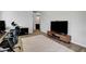Modern living room featuring sleek furniture and a large flat-screen TV with wood look tile flooring at 10433 Ember Rose Ave, Las Vegas, NV 89135