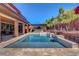 Beautiful backyard with a swimming pool, outdoor kitchen, and meticulously landscaped surroundings at 10433 Ember Rose Ave, Las Vegas, NV 89135