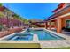 Beautiful backyard offering a pool, spa, covered patio, and meticulously landscaped retaining wall with privacy at 10433 Ember Rose Ave, Las Vegas, NV 89135