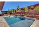 Amazing backyard featuring a custom pool, hot tub, and outdoor kitchen area surrounded by lush landscaping at 10433 Ember Rose Ave, Las Vegas, NV 89135