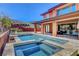 Beautiful pool and spa with covered patio, mountain views, and a landscaped retaining wall providing ultimate relaxation at 10433 Ember Rose Ave, Las Vegas, NV 89135