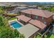 Drone shot of a backyard featuring a private pool, covered patio, and landscaped garden area of a home at 10433 Ember Rose Ave, Las Vegas, NV 89135
