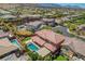 Aerial view of a backyard oasis featuring a pool, spa, covered patio, and lush landscaping in a suburban setting at 10433 Ember Rose Ave, Las Vegas, NV 89135