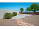 Landscaped backyard features a gravel ground cover, lush bushes, and a charming stone pathway at 10720 Bennington Ct, Las Vegas, NV 89134
