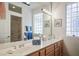 Double sink bathroom featuring a large vanity, ample storage, and glass block window at 10720 Bennington Ct, Las Vegas, NV 89134
