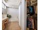 Bathroom showcasing a vanity, soaking tub, and a walk-in closet with custom shelving at 10720 Bennington Ct, Las Vegas, NV 89134