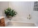Close up of a bathroom featuring a garden tub, neutral countertops, and natural light at 10720 Bennington Ct, Las Vegas, NV 89134