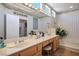 Bright bathroom featuring double sinks, vanity, large mirror, and a soaking tub at 10720 Bennington Ct, Las Vegas, NV 89134