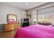 Bright bedroom featuring a dresser with mirror, TV, and comfortable seating area with scenic views at 10720 Bennington Ct, Las Vegas, NV 89134