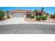 Inviting single-story home with a well-manicured lawn, desert landscaping, and an attached two-car garage at 10720 Bennington Ct, Las Vegas, NV 89134