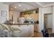 Spacious kitchen features a breakfast bar with seating, light wood cabinetry, and modern appliances at 10720 Bennington Ct, Las Vegas, NV 89134