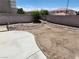 Open backyard space with a small concrete patio and rock landscaping against a block wall at 10968 Geyser Peak St, Henderson, NV 89052