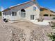 Wide backyard featuring a concrete patio, gravel landscaping, and mature plants at 10968 Geyser Peak St, Henderson, NV 89052