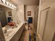 Bathroom featuring double sinks, white cabinets, large mirror, and shower with floral curtains at 10968 Geyser Peak St, Henderson, NV 89052