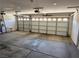 Large three-car garage featuring multiple paneled doors, concrete floor, and overhead lighting at 10968 Geyser Peak St, Henderson, NV 89052