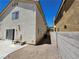 Side yard featuring a small patio area, gravel landscaping, and access to the backyard, offering privacy at 10968 Geyser Peak St, Henderson, NV 89052