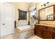 Bright bathroom with a soaking tub, granite countertops, and a view from the window at 11 Via Vita Bella, Henderson, NV 89011