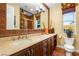 Well-lit bathroom featuring a large vanity with double sinks and decorative brick accents at 11 Via Vita Bella, Henderson, NV 89011