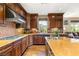 Gourmet kitchen with dark wood cabinetry, tile backsplash and granite countertops at 11 Via Vita Bella, Henderson, NV 89011