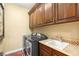 Functional laundry room featuring stainless steel appliances, sink, and ample cabinet space at 11 Via Vita Bella, Henderson, NV 89011