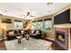 Comfortable living room with decorative fireplace, ceiling fan and dark wood floors at 11 Via Vita Bella, Henderson, NV 89011