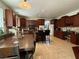Bright eat-in kitchen featuring cherry wood cabinetry, an island, and tile floors at 11457 Steponia Bay St, Las Vegas, NV 89141