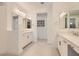 Bright bathroom with separate vanities and a view into a hallway at 130 W Fairway Rd, Henderson, NV 89015
