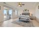 Cozy bedroom with a gray upholstered bed, sliding doors to the patio, and light wood flooring at 130 W Fairway Rd, Henderson, NV 89015
