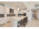 Bright, white kitchen featuring a large island with seating, pendant lighting, and stainless steel appliances at 130 W Fairway Rd, Henderson, NV 89015