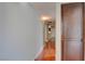 Hallway featuring gleaming hardwood floors, light-colored walls and a dark brown storage cabinet at 1405 S Nellis Blvd # 2117, Las Vegas, NV 89104