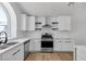 Updated kitchen featuring an arched window, new wood floors, and stainless steel appliances at 1638 Candice St, Las Vegas, NV 89156