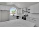 Bright kitchen featuring white cabinets, marble countertops, stainless appliances, and a large arched window at 1638 Candice St, Las Vegas, NV 89156